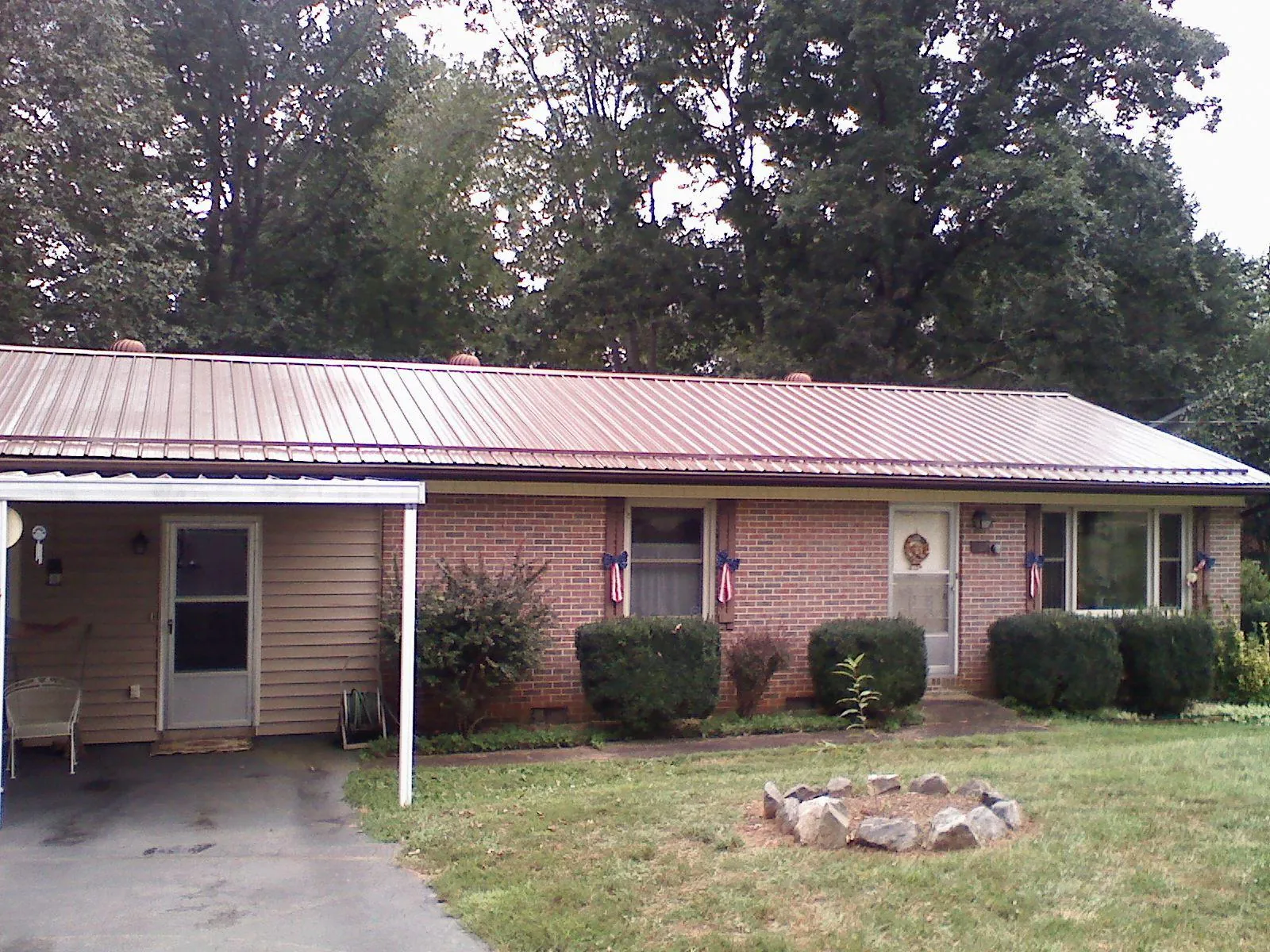 Bronze metal roof and carport on a brick ranch home — Roof Repair work by our crew in Ione